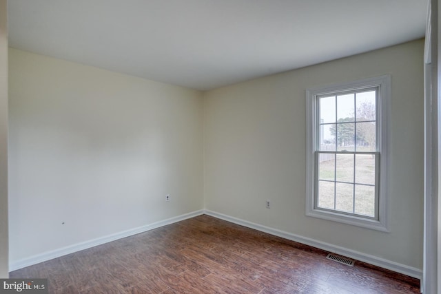 spare room featuring dark wood-type flooring