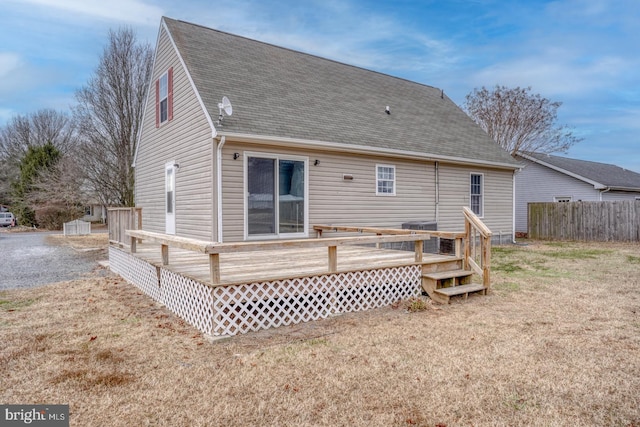 back of property featuring a deck and a lawn