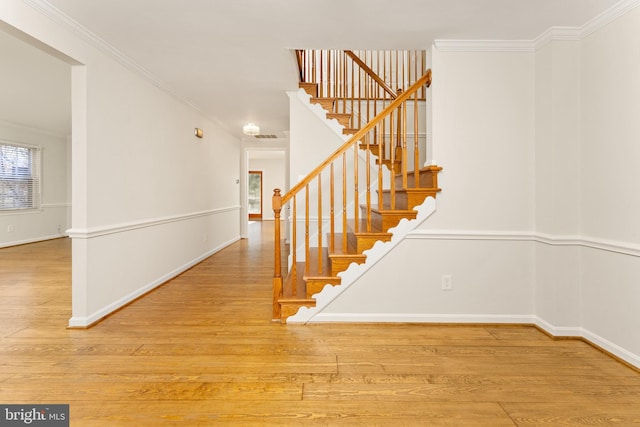 stairway featuring hardwood / wood-style floors and ornamental molding