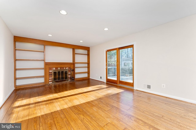 unfurnished living room with a fireplace and hardwood / wood-style floors