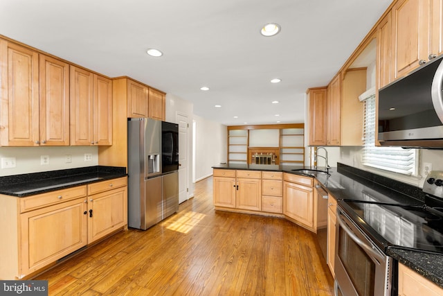 kitchen with appliances with stainless steel finishes, light hardwood / wood-style floors, light brown cabinetry, and sink