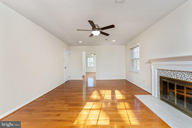 unfurnished living room featuring a fireplace, hardwood / wood-style flooring, and ceiling fan