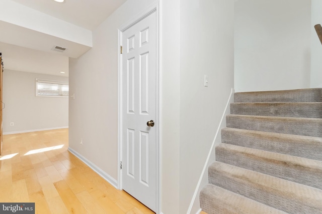 stairway with a barn door and hardwood / wood-style flooring