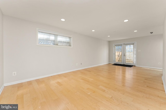 empty room with french doors and light wood-type flooring