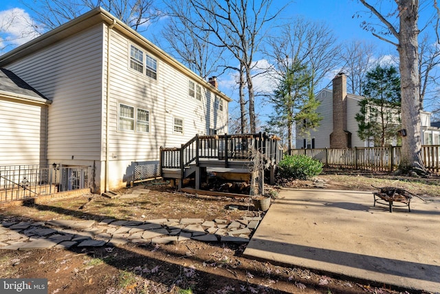 back of house with a fire pit and a wooden deck