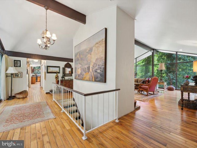 hallway with a chandelier, vaulted ceiling with beams, and light hardwood / wood-style floors