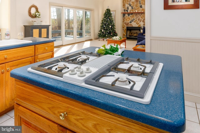 room details with wood walls, sink, white gas cooktop, and a fireplace