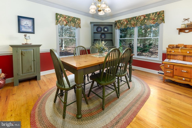 dining space with a chandelier, light hardwood / wood-style floors, and crown molding