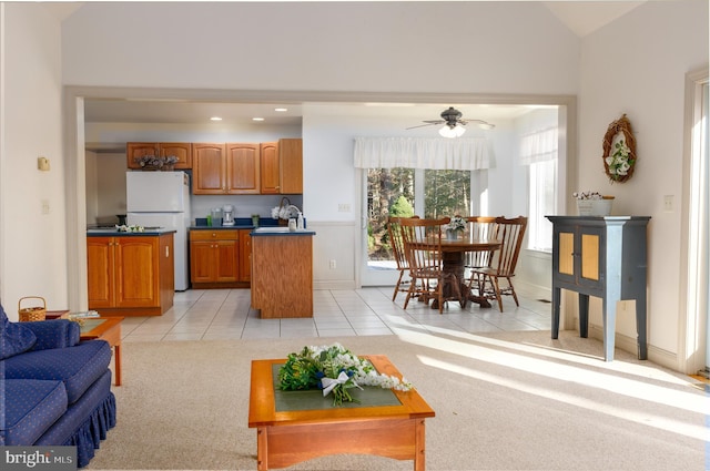 living room featuring light carpet, vaulted ceiling, ceiling fan, and sink