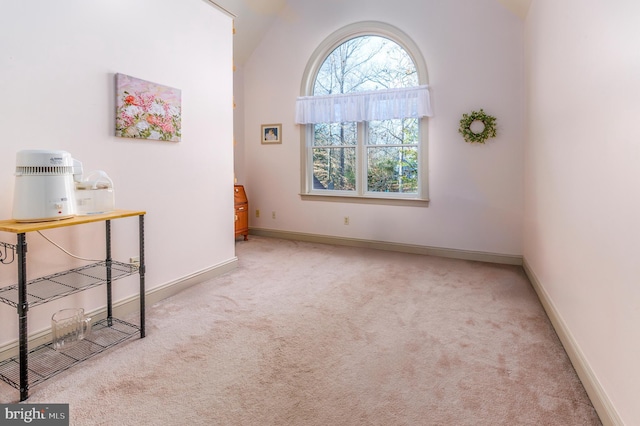 unfurnished room featuring light colored carpet and vaulted ceiling