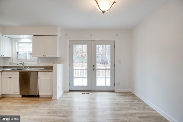 kitchen with french doors, white cabinetry, a wealth of natural light, and stainless steel dishwasher