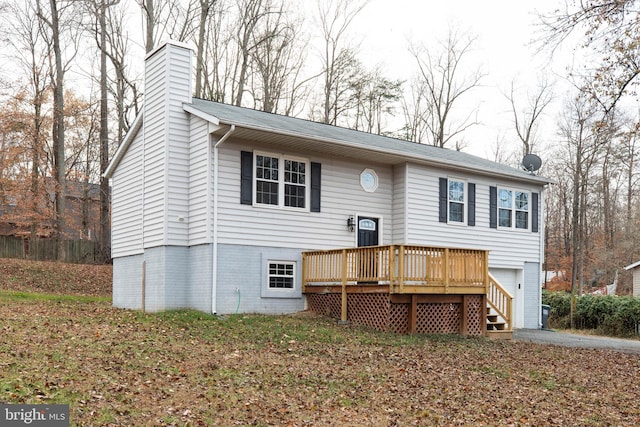 split foyer home featuring a garage and a wooden deck