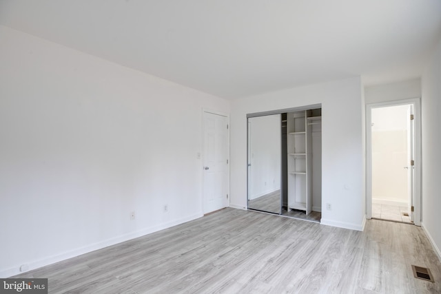 unfurnished bedroom featuring light wood-type flooring and a closet