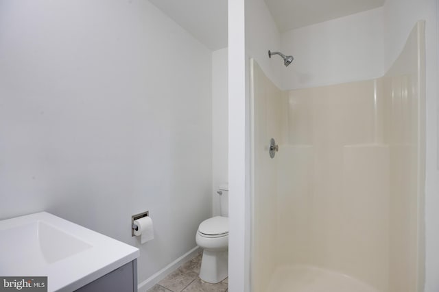 bathroom with tile patterned flooring, vanity, toilet, and walk in shower