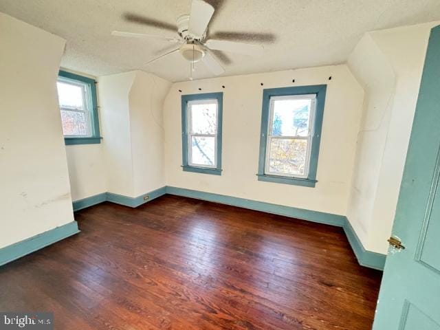 bonus room with a textured ceiling, dark hardwood / wood-style flooring, and ceiling fan