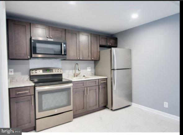 kitchen featuring sink, stainless steel appliances, and dark brown cabinets