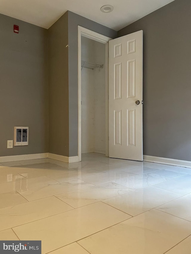 unfurnished bedroom with tile patterned flooring and a closet