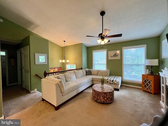 carpeted living room featuring ceiling fan with notable chandelier and a textured ceiling