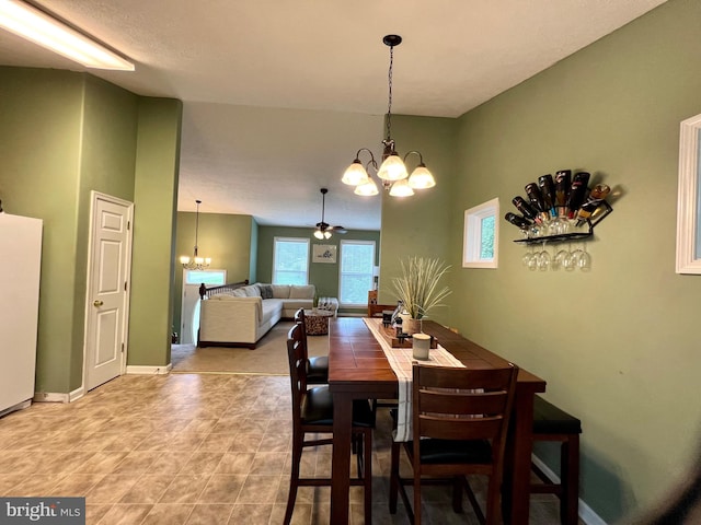 dining space with ceiling fan with notable chandelier