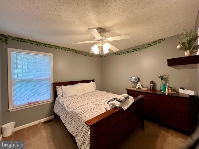 bedroom with ceiling fan, dark carpet, and a textured ceiling