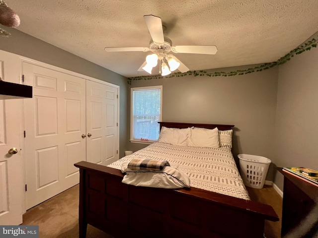 bedroom featuring a textured ceiling, carpet floors, a closet, and ceiling fan