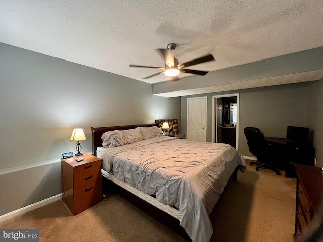 bedroom featuring ceiling fan, carpet floors, and a textured ceiling