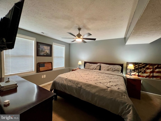 bedroom featuring carpet flooring, ceiling fan, and a textured ceiling