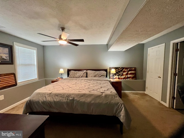 carpeted bedroom with ceiling fan and a textured ceiling