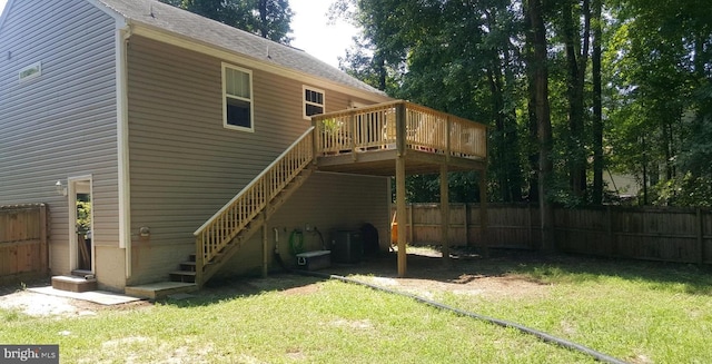 rear view of house featuring a yard, a wooden deck, and central AC