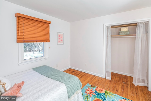 bedroom with wood-type flooring and a closet