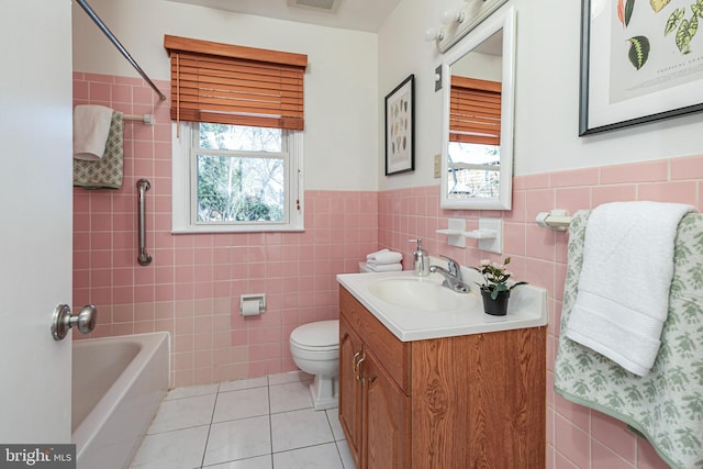 full bathroom with tile patterned floors, toilet, tile walls, shower / tub combination, and vanity