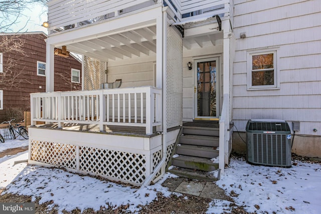 snow covered property entrance featuring central air condition unit