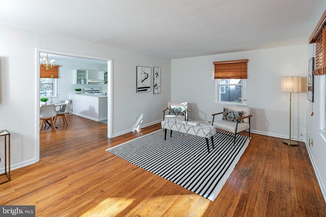 living room with a healthy amount of sunlight, hardwood / wood-style floors, and a notable chandelier