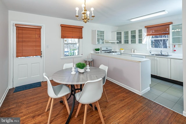 dining space with sink, a notable chandelier, and light hardwood / wood-style flooring