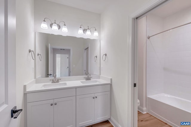 full bathroom featuring toilet, vanity, tub / shower combination, and hardwood / wood-style flooring