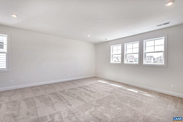 unfurnished room featuring light carpet