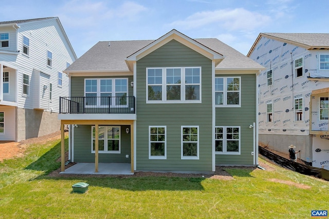 rear view of property featuring a lawn and a patio