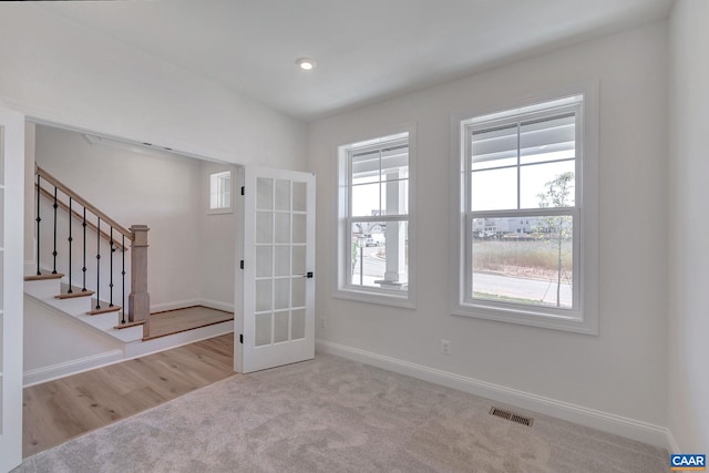 empty room with french doors and light wood-type flooring