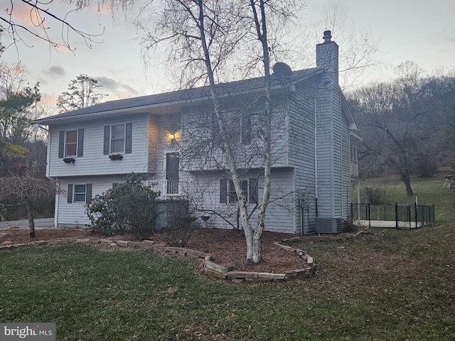 view of home's exterior with central air condition unit and a lawn