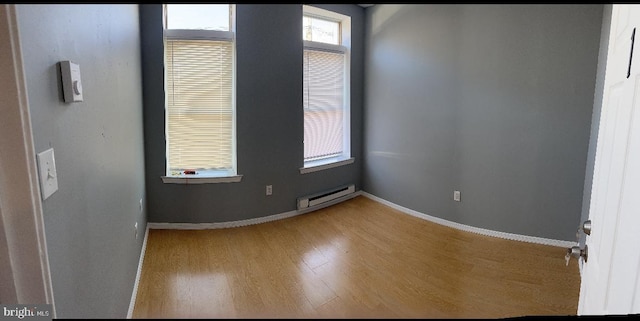 unfurnished room featuring light wood-type flooring and a baseboard radiator