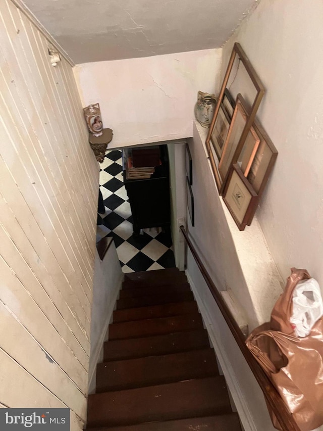 stairway featuring wood walls and hardwood / wood-style flooring