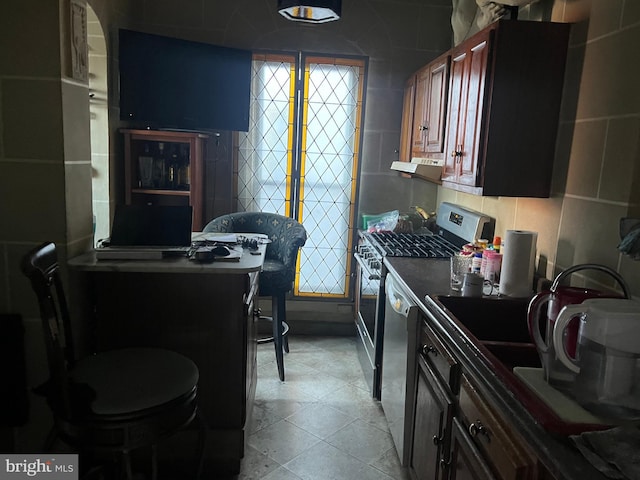 kitchen with exhaust hood, tile walls, and appliances with stainless steel finishes