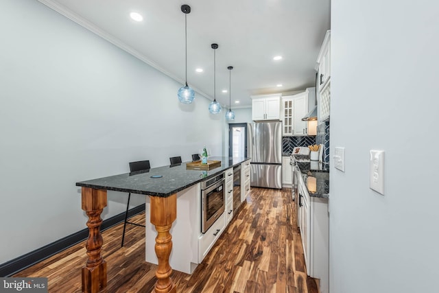 kitchen featuring a breakfast bar, white cabinets, hanging light fixtures, appliances with stainless steel finishes, and a kitchen island