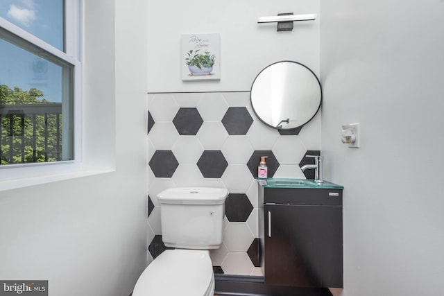 bathroom featuring backsplash, vanity, tile walls, and toilet