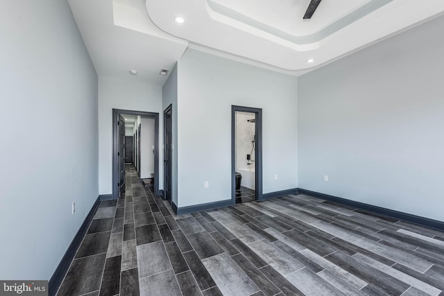 unfurnished room featuring dark hardwood / wood-style flooring and a tray ceiling