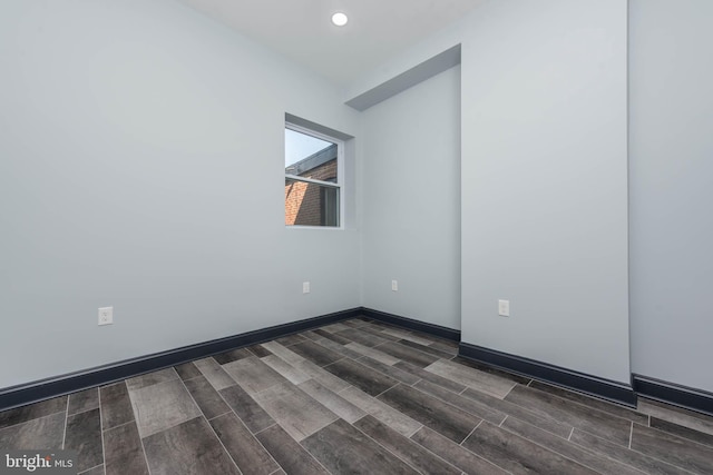 unfurnished room with dark wood-type flooring