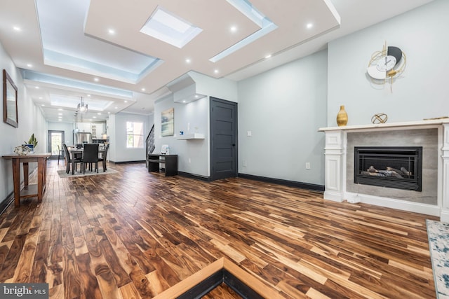 living room with a tray ceiling and dark wood-type flooring