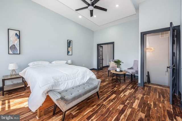 bedroom featuring ceiling fan, a towering ceiling, and dark wood-type flooring