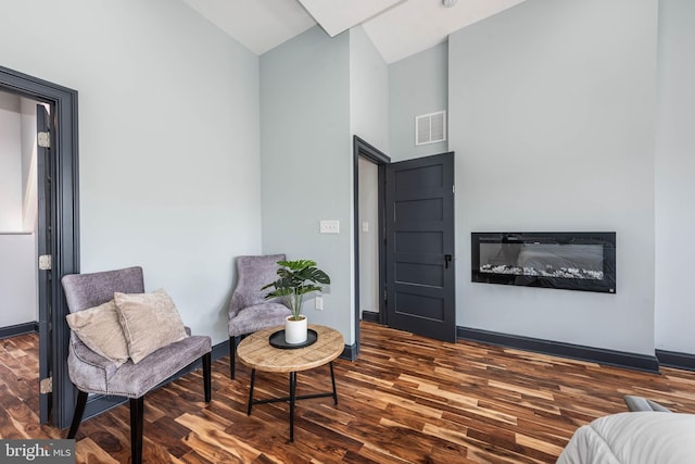 living area featuring lofted ceiling and dark wood-type flooring