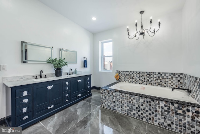 bathroom featuring tiled bath, vanity, and a notable chandelier